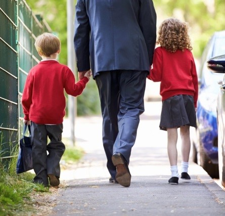 Picture of man walking two children to school